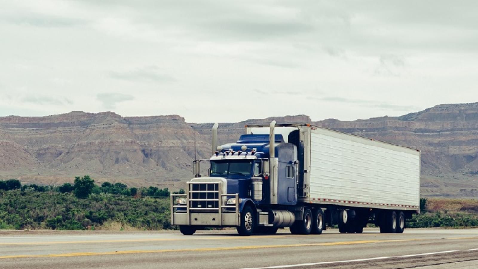A loaded reefer truck on the highway through desert canyon country