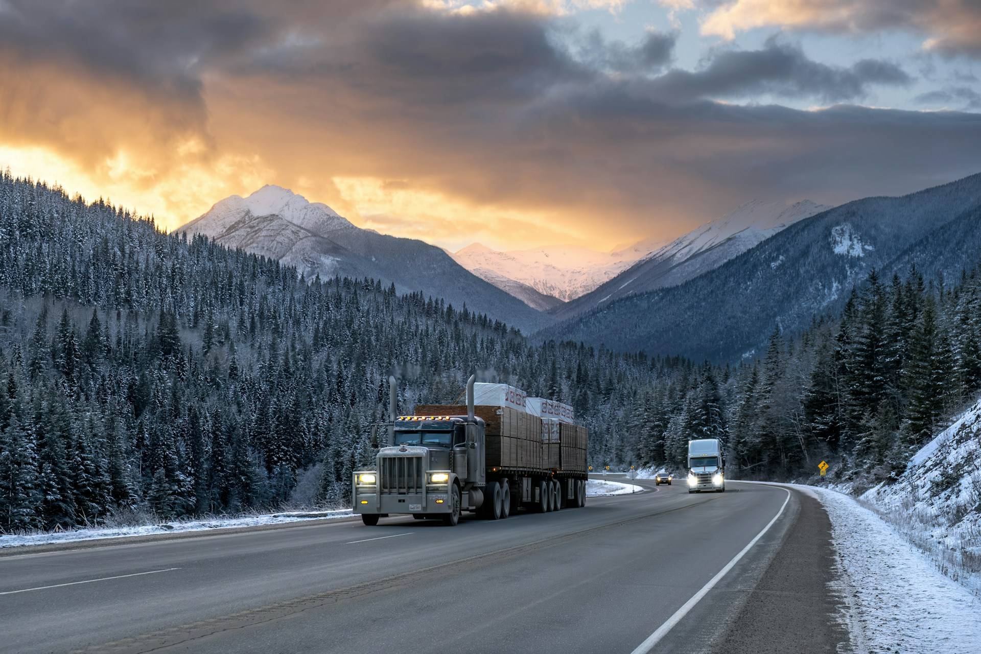 A loaded flatbed truck on the highway through the BC mountains